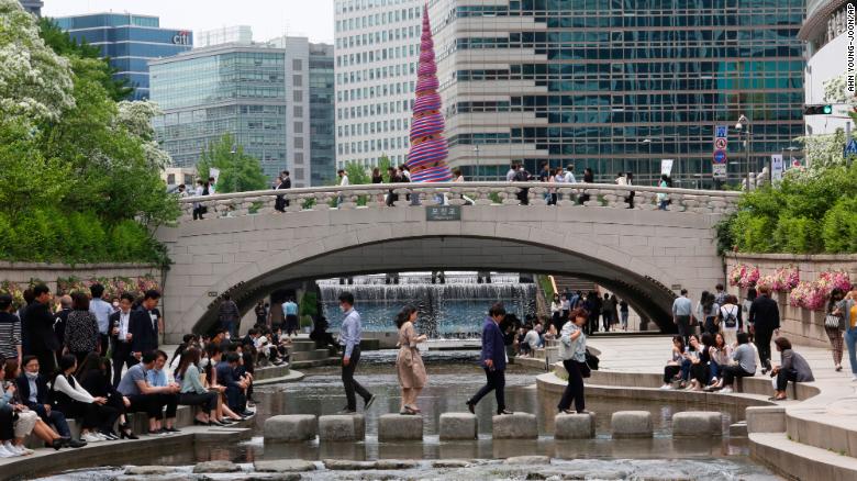 People relax at the Cheonggye Stream in the South Korean capital, Seoul, on Thursday amid a lifting of restrictions in the wake of the coronavirus pandemic.