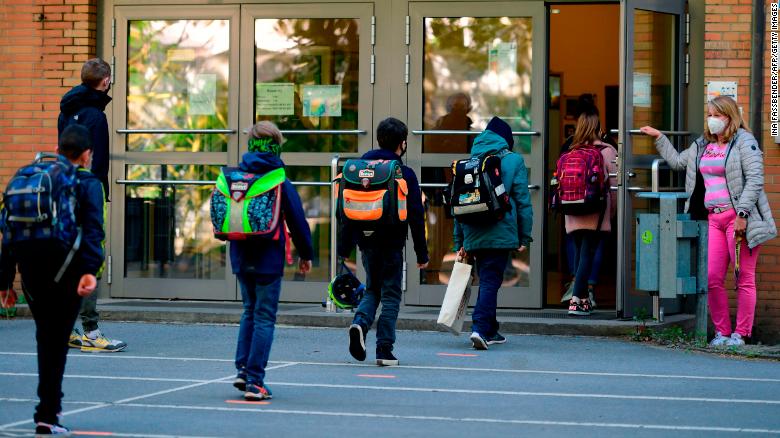 Children respect social distancing rules as they enter the Petri primary school in Dortmund, western Germany, on Thursday, as the school reopens for some pupils.