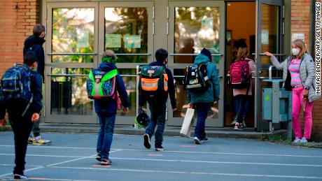 Children respect social distancing rules as they enter the Petri primary school in Dortmund, western Germany, on Thursday, as the school reopens for some pupils.