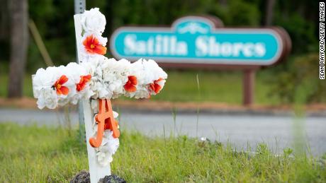 A cross with flowers and a letter "A" sits at the entrance to the Satilla Shores neighborhood where Ahmaud Arbery was shot and killed in Brunswick, Georgia. 