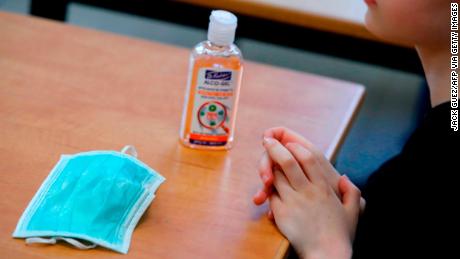 A hand sanitizer and a mask sit on a student&#39;s desk at an elementary school in Pardes Hanna-Karkur in central Israel.