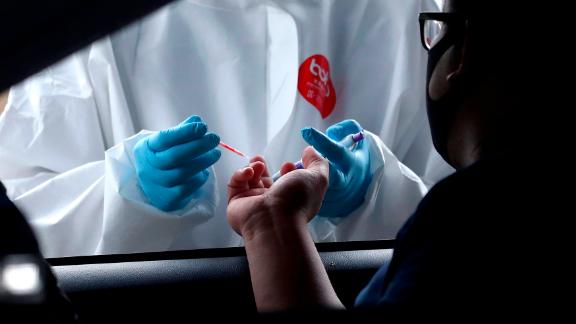A health worker collects a man's blood sample for a coronavirus antibody test in Tangerang, Indonesia, on May 4.