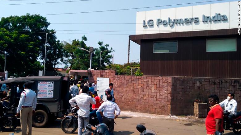 Policemen stand guard as people gather in front of the plant following the gas leak incident.