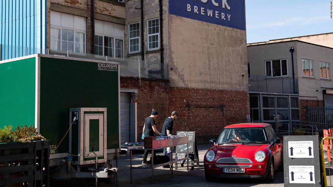 Staff members at the Castle Rock Brewery in Nottingham, England, operate a drive-thru beer station on April 4.