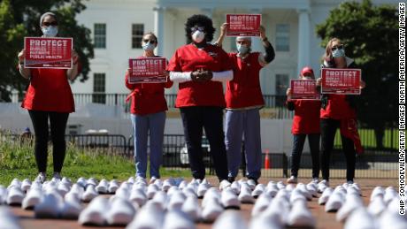 Members of the National Nurses United protest  across from the White House on Thursday. The nurses say the shoes represent other nurses who&#39;ve died from Covid-19. 