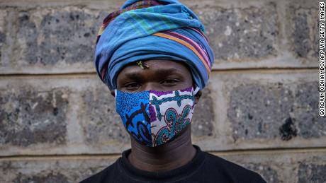 Kenyan fashion designer of &quot;Lookslikeavido&quot;, David Avido, poses for a portrait at his studio in Kibera, Nairobi, with a mask he created to hand out to people for free. 