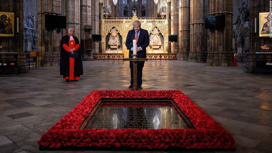 British Prime Minister Boris Johnson lights a candle at the grave of the Unknown Warrior in London&#39;s Westminster Abbey.