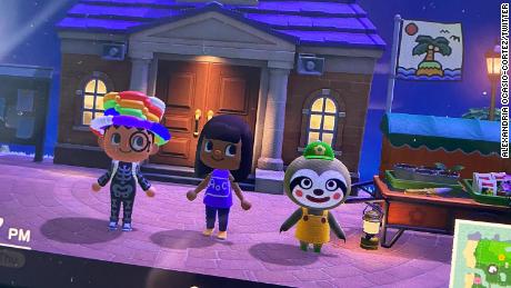 Alexandria Ocasio-Cortez tweeted this photo showing her &quot;Animal Crossing&quot; game. The figure in the center, Ocasio-Cortez&#39;s apparent avatar, is sporting a custom &quot;AOC&quot; T-shirt, while the figure on the right is a sloth who sells plants. 