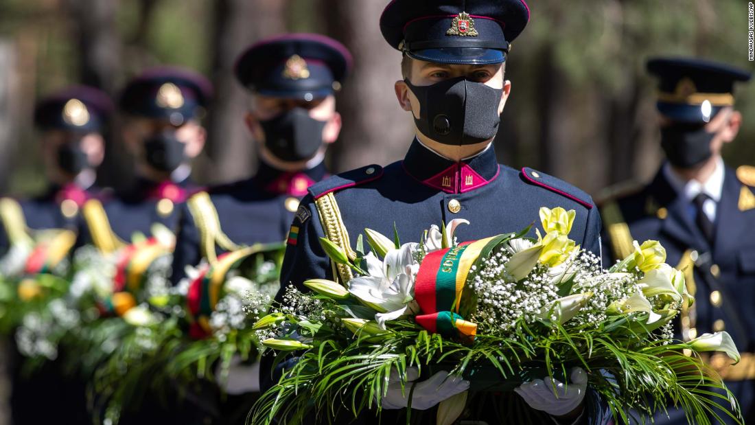 Soldiers wear protective face masks at a VE Day memorial in Vilnius, Lithuania, on Friday, May 8.