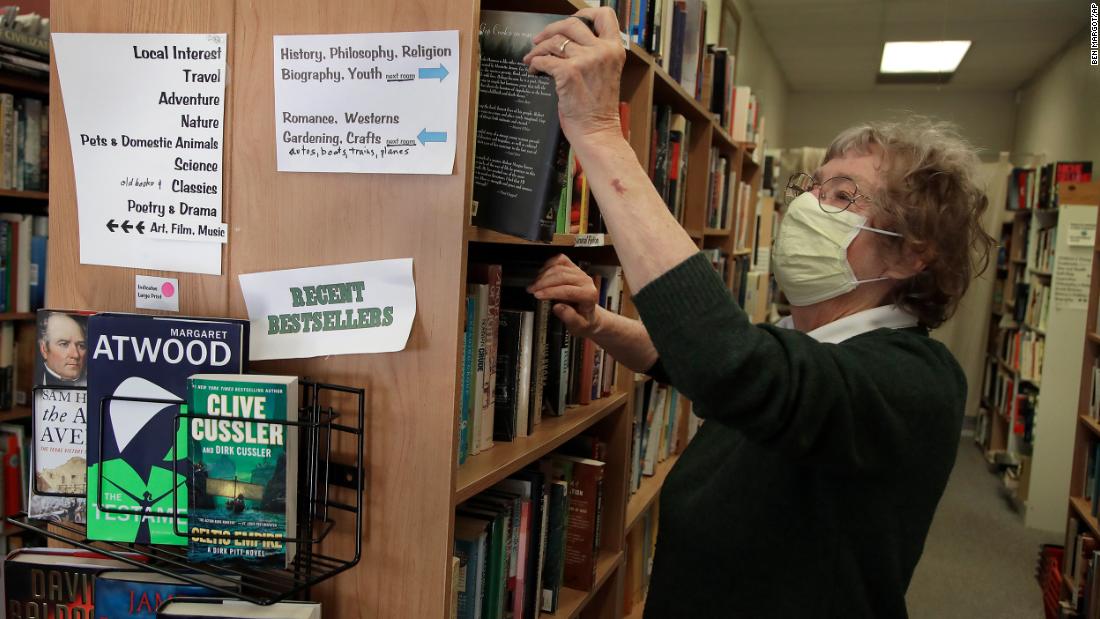 Sue Conklin, owner of Books Rio V, stocks her shelves in Rio Vista, California, on May 8. It was her first day back at the used bookstore since March 28.