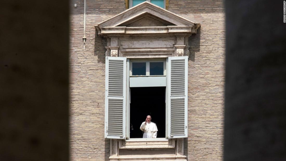 Pope Francis delivers a blessing from the window of his studio overlooking an empty St. Peter&#39;s Square.