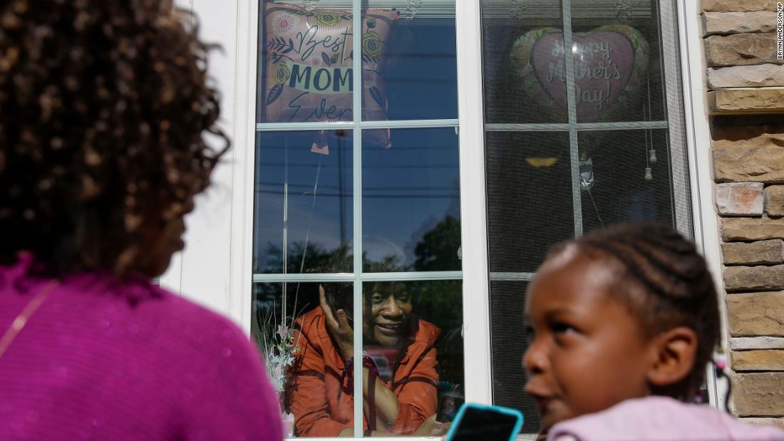 Mary Washington speaks through a window to her daughter Courtney Crosby and grandchild Sydney Crosby during a Mother&#39;s Day celebration at her senior-living facility in Smyrna, Georgia.