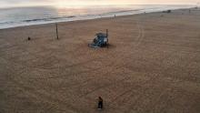 VENICE, CALIFORNIA  - APRIL 26: An aerial view of people embracing before sunset on a nearly empty Venice Beach, which remains closed along with all other Los Angeles County beaches under stay-at-home orders, amid the coronavirus pandemic on April 26, 2020 in Venice, California. Neighboring Orange County's beaches remain open with an estimated 40,000 people visiting Newport Beach on April 24 as the spread of COVID-19 continues. (Photo by Mario Tama/Getty Images)