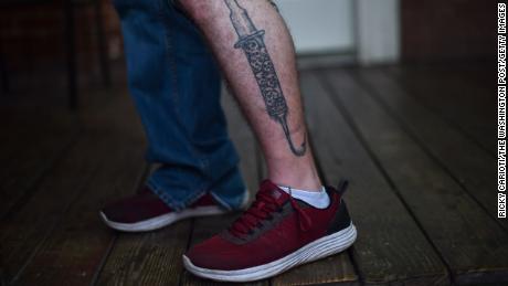 Eric, a recovering addict, shows off his syringe and hook tattoo at a recovery center in Huntington, West Virginia.