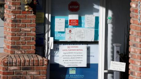 Warning notices were posted on a door at an entrance to the Cedar Mountain Post Acute nursing facility in Yucaipa, Calif. There have been 21 resident deaths there -- the highest number of Covid-19 deaths in any facility in San Bernardino County.