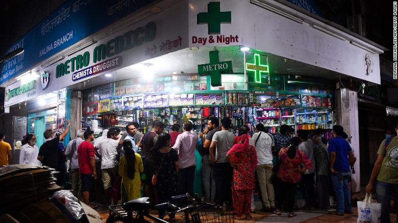 People gather at a pharmacy to buy supplies following Indian Prime Minister&#39;s announcement of a government-imposed nationwide lockdown as a preventive measure against the Covid-19 in Mumbai on March 24, 2020. 