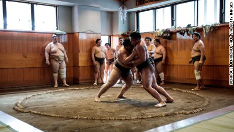 Sumo wrestlers try to push each other out of the ring or &quot;dohyo&quot; during a training session at a stable in Tokyo.