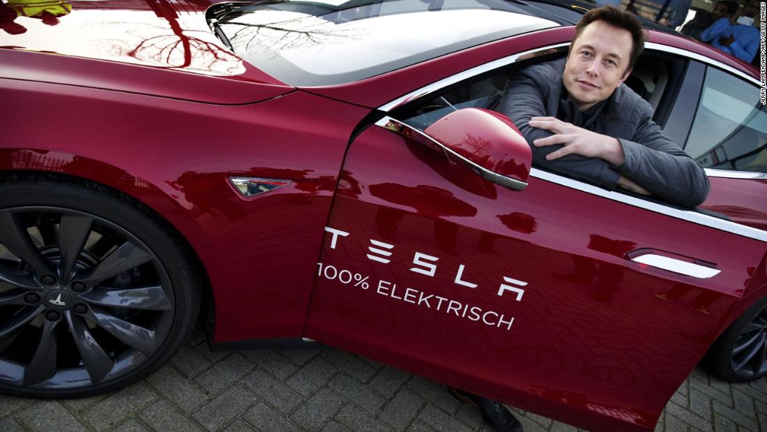 Musk poses with a Tesla during a visit to Amsterdam, Netherlands, in 2014.