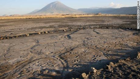 The Engare Sero footprint site is in Tanzania, which preserves at least 408 human footprints. An eruption of Oldoinyo L'engai, the volcano in the background, produced the ash in which the footprints were preserved, according to the researchers. 