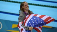 Franklin carries a US flag from the podium after recieving her gold medal for the women&#39;s 100-meter backstroke final at the London 2012 Olympic Games.