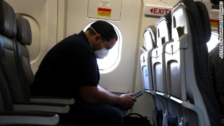 A passenger looks at his phone while waiting aboard a United Airlines plane before taking off from George Bush Intercontinental Airport on May 11, 2020 in Houston, Texas. 