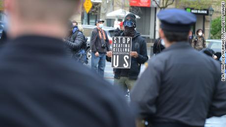 A group of protesters, bound together with yellow caution tape, marched on New York&#39;s Police Headquarters on May 11, 2020, decrying police brutality against African-Americans. 