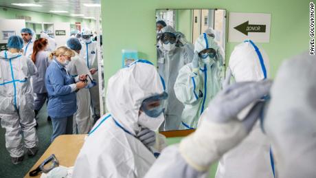 Medical workers put on protective gear before assisting coronavirus patients at the Filatov City Clinical Hospital in Moscow, Russia, Friday, May 15, 2020. Russian capital, with a population of more than 12 million, accounts for half of the country's more than 262,000 reported infections. (AP Photo/Pavel Golovkin)