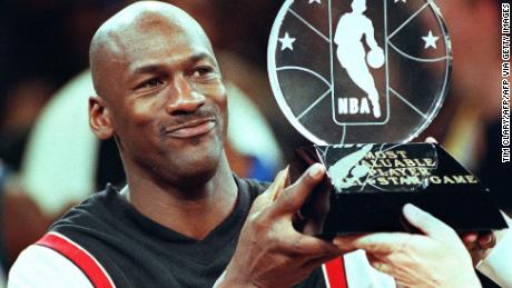 Chicago Bulls&#39; Michael Jordan holds up the Most Valuable Player trophy.