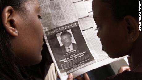 Readers look at a newspaper on June 12, 2002 in Nairobi carrying the photograph of Rwandan Felicien Kabuga.