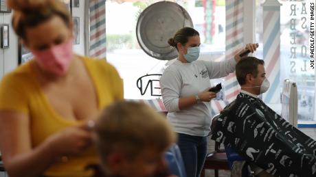 A hairstylist cuts the hair of a customer at a recently reopened barber shop in Fort Lauderdale, Florida, on May 18.