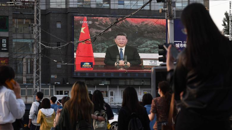 Chinese President Xi Jinping speaking via video link to the World Health Assembly, on a giant screen beside a street in Beijing on May 18, 2020.  