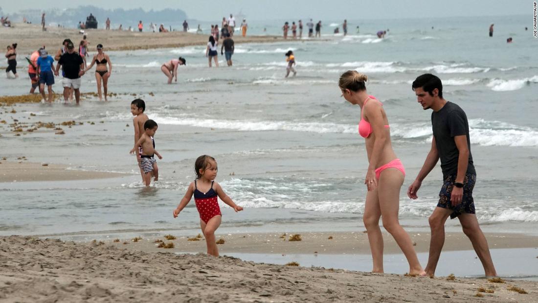 People enjoy the water as Florida&#39;s Palm Beach County reopened some beaches on May 18. Social-distancing rules were still in effect.