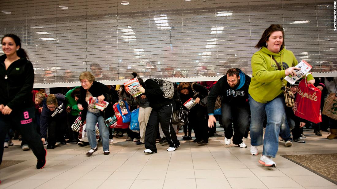 Black Friday shoppers duck under the opening door of a Sears store in Mentor, Ohio, in 2011.
