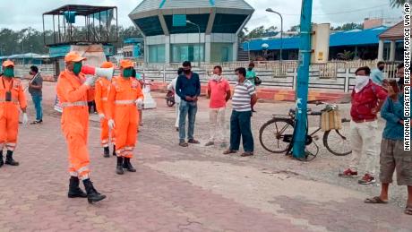 Members of India's National Disaster Response Force warn people on the Bay of Bengal coast at Namkhana, West Bengal, on May 19