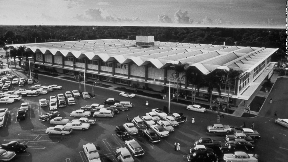 Cars fill a parking lot outside a Sears store, circa 1958.