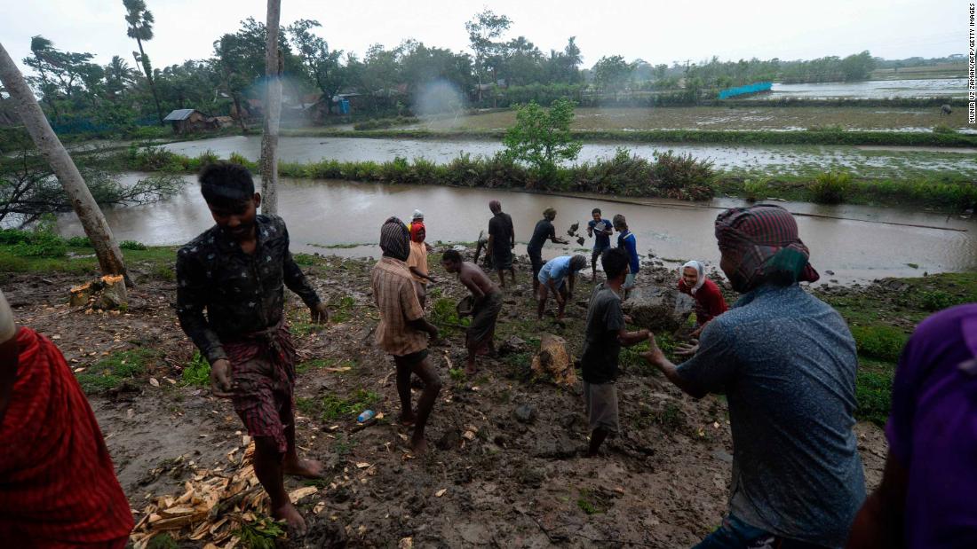 Villagers reinforce an embankment with sacks of soil in Dacope.