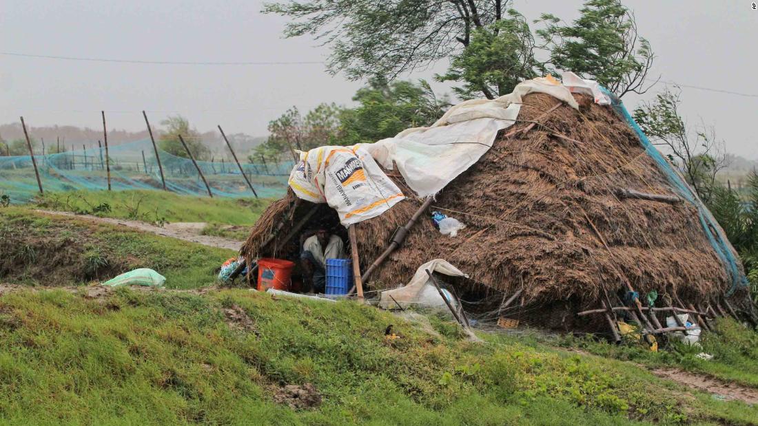 A man takes shelter inside a hut in India&#39;s Bhadrak district.