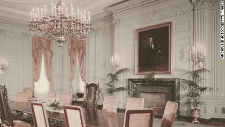 Un portret al fostului președinte Abraham Lincoln de George Peter Alexander Healy atârnă deasupra șemineului în sala de mese de stat la Casa Albă în 1962. 