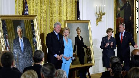 Fostul președinte Bill Clinton și fosta primă doamnă Hillary Clinton stau alături de portretele lor oficiale de la Casa Albă, în timpul ceremoniei de dezvăluire desfășurate de fostul președinte George W. Bush și prima doamnă Laura Bush în iunie 2004 la Casa Albă.