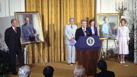 Președintele Jimmy Carter comentează dezvelirea portretelor fostului președinte Gerald R. Ford și ale fostei doamne Betty Ford în camera de est a Casei Albe din august 1980. 