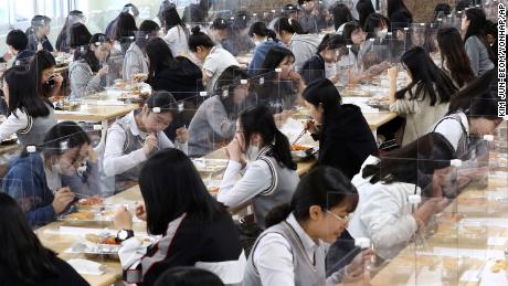 Senior students eat lunch at tables equipped with plastic barriers to prevent possible spread of coronavirus in the cafeteria at Jeonmin High School in Daejeon, South Korea, Wednesday, May 20, 2020.