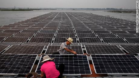 Workers prepare part of a large floating solar farm project under construction in June 2017 in Huainan, Anhui province, China.