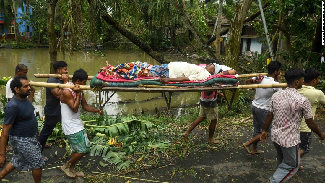 People carry Tapas Pramanik to receive medical treatment after his leg was broken by a fallen tree in Midnapore, India, on May 21.