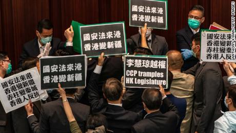 HONG KONG, CHINA - MAY 22:  Pro-democracy lawmakers hold placards to protest against the pro-Beijing lawmakers at the House Committee&#39;s election of vice chairpersons, presided by pro-Beijing lawmaker Starry Lee Wai-King at the Legislative Council on May 22, 2020 in Hong Kong, China. Chinese Premier Li Keqiang said on Friday during the National People&#39;s Congress that Beijing would establish a sound legal system and enforcement mechanism for safeguarding national security in Hong Kong. (Photo by Anthony Kwan/Getty Images)