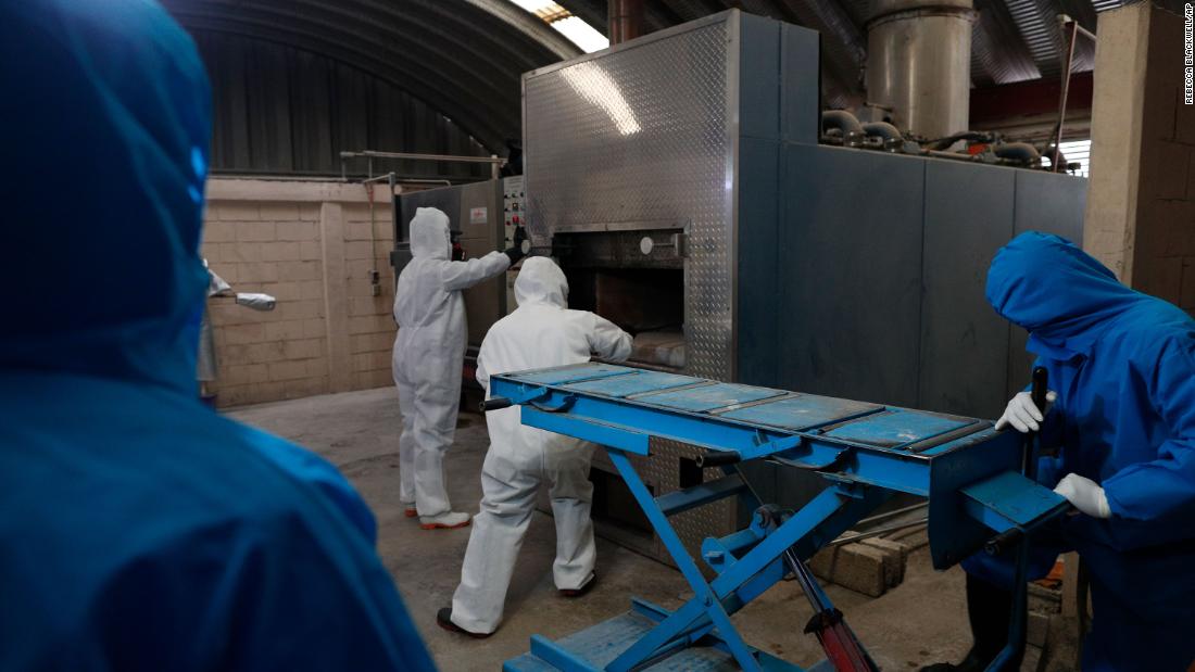 Workers wear protective gear as they start a cremation oven in Ecatepec, Mexico.