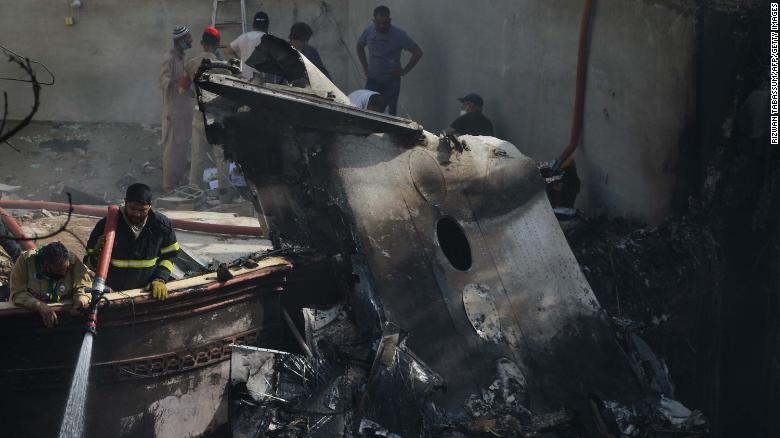 A firefighter sprays water on the wreckage of a Pakistan International Airlines aircraft after it crashed in a residential area in Karachi on Friday.