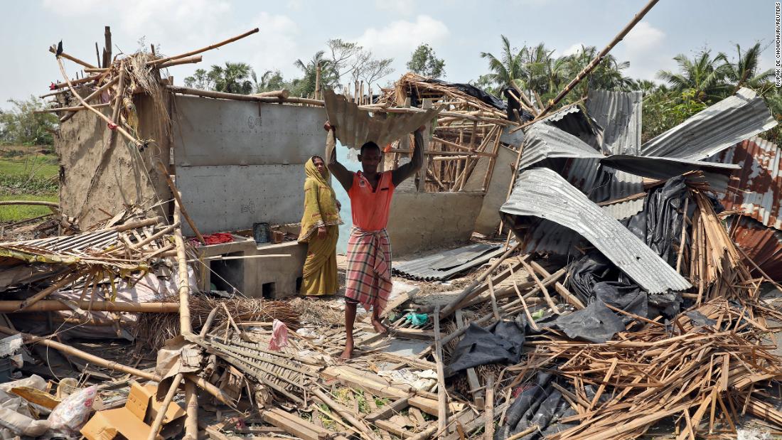 A man carries a tin sheet salvaged from the rubble of his damaged house in West Bengal, India, on Friday, May 22.