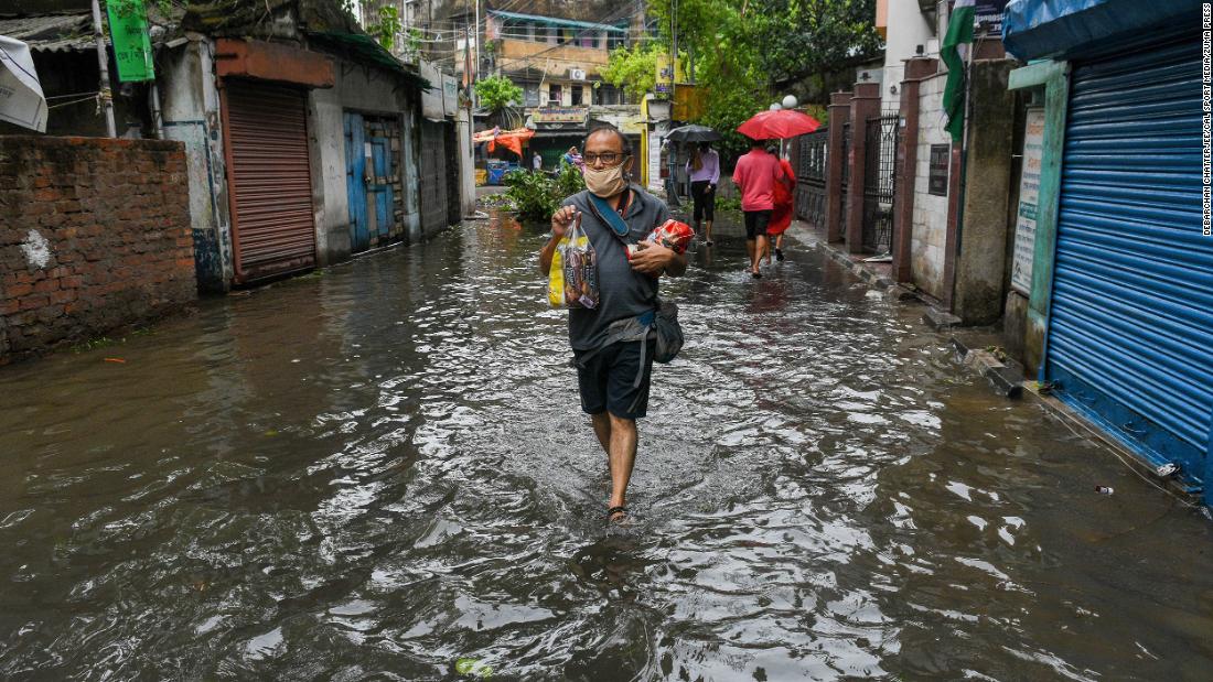 A man walks through a flooded street in Kolkata on May 21.