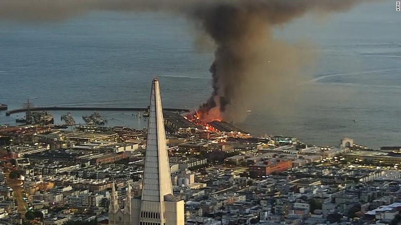 Pier 45 burns in San Francisco, with the Transamerica Pyramid in the foreground.