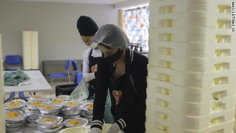 Voluntarii pregătesc unele dintre cele 10.000 de mese care sunt distribuite zilnic rezidenților din favela Paraisopolis, astfel încât nu trebuie să își părăsească casele pentru a mânca.